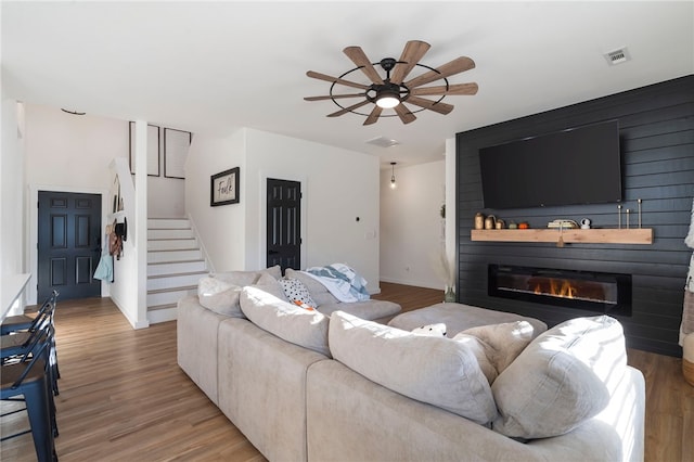 living area featuring wood finished floors, a ceiling fan, and visible vents