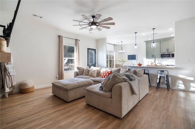 living area with visible vents, a ceiling fan, wood finished floors, recessed lighting, and baseboards