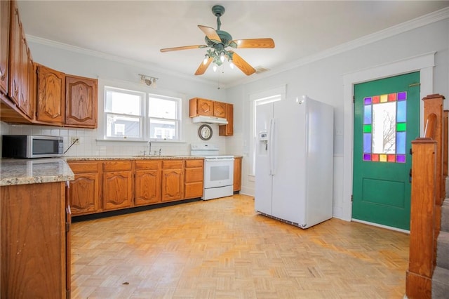 kitchen with tasteful backsplash, brown cabinets, white appliances, and ornamental molding