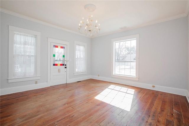 foyer with light wood finished floors, an inviting chandelier, baseboards, and ornamental molding