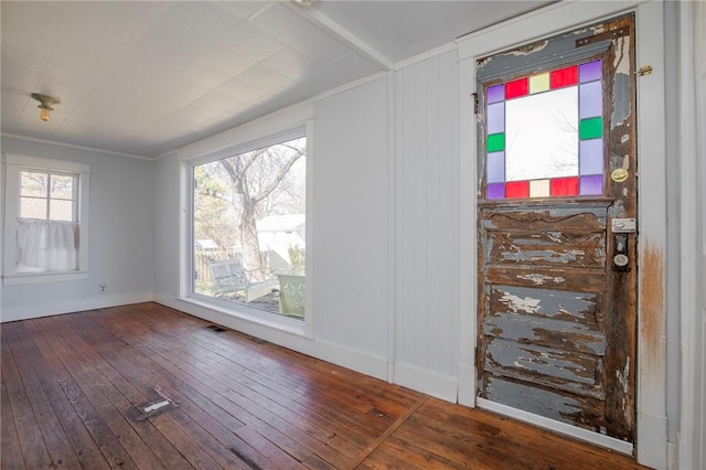 spare room featuring visible vents, hardwood / wood-style floors, and ornamental molding