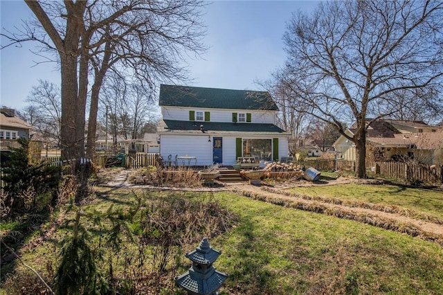 view of front of house featuring a deck, a front yard, and fence