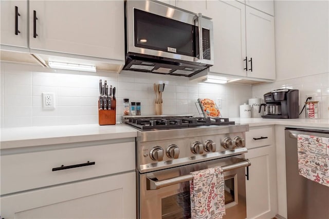 kitchen featuring decorative backsplash, appliances with stainless steel finishes, white cabinetry, and light countertops