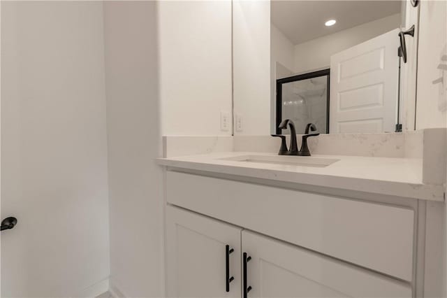 bathroom featuring recessed lighting, baseboards, a shower stall, and vanity