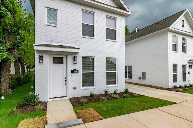 view of front of house with brick siding and a front yard