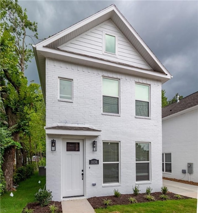 view of front of house with brick siding and a front lawn