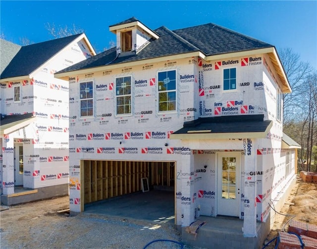 view of front of house featuring an attached garage and a shingled roof