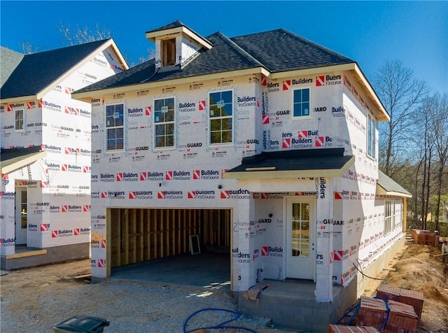 view of front of house with a garage, driveway, and a shingled roof