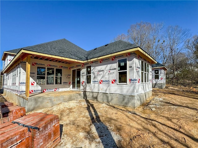 back of property featuring roof with shingles