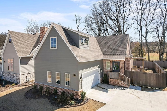 view of front facade featuring fence, concrete driveway, a shingled roof, a garage, and brick siding