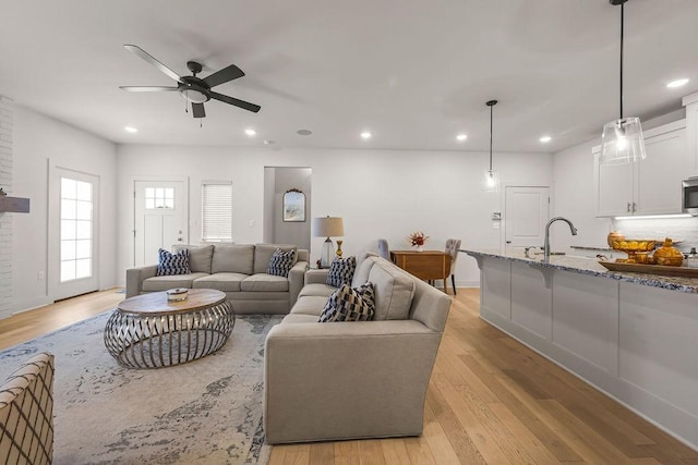 living area with recessed lighting, light wood-style flooring, and a ceiling fan