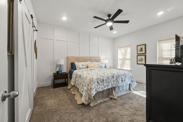 bedroom featuring a ceiling fan, carpet, baseboards, recessed lighting, and a barn door