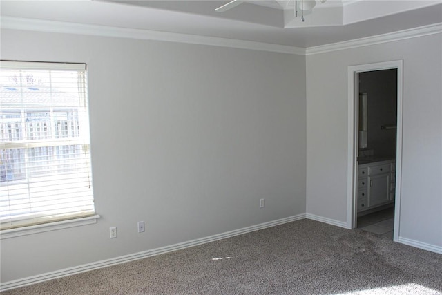 carpeted empty room featuring crown molding, baseboards, and ceiling fan