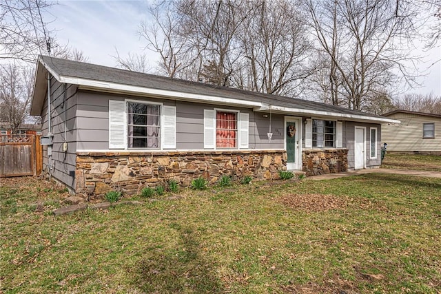 ranch-style home featuring a front lawn, fence, and stone siding