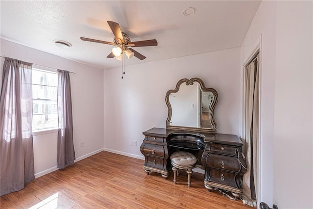 interior space with a ceiling fan, wood finished floors, and baseboards