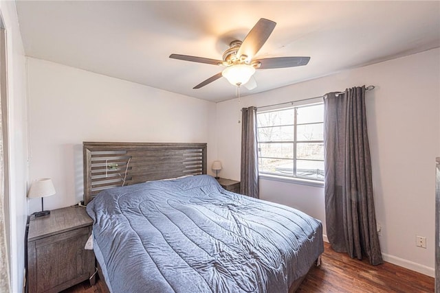 bedroom featuring ceiling fan, baseboards, and wood finished floors