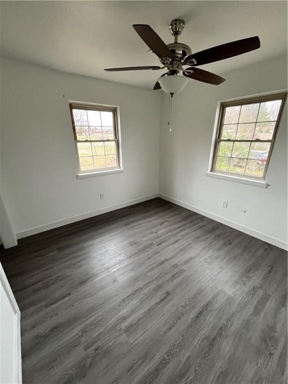 unfurnished room with baseboards and dark wood-type flooring