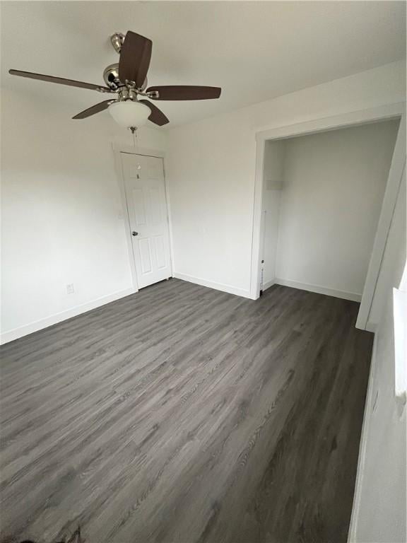 unfurnished bedroom with dark wood finished floors, a ceiling fan, and baseboards