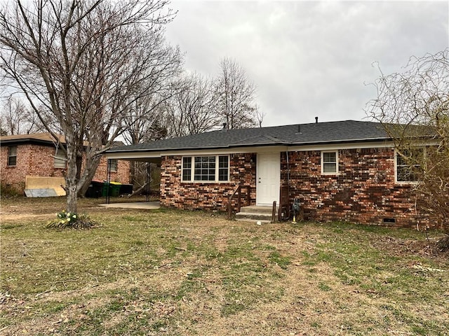 back of house featuring a shingled roof, a lawn, brick siding, and crawl space