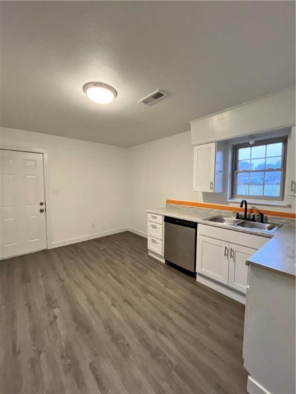 kitchen with visible vents, a sink, stainless steel dishwasher, dark wood-style floors, and white cabinets