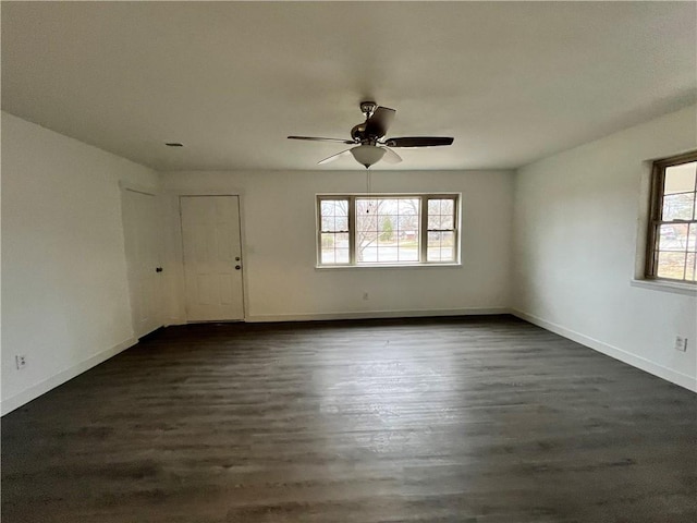 unfurnished room featuring dark wood finished floors, a healthy amount of sunlight, and baseboards