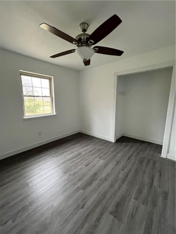 unfurnished bedroom featuring baseboards, ceiling fan, and dark wood-style flooring