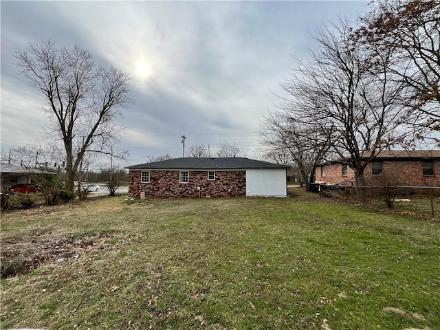 rear view of house with a lawn and fence