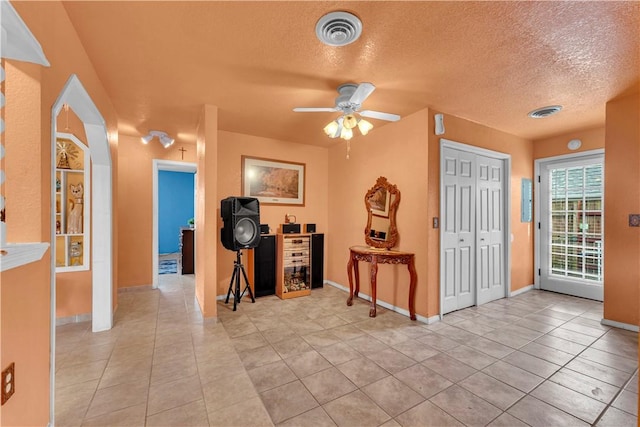 entrance foyer featuring light tile patterned floors, visible vents, and a textured ceiling