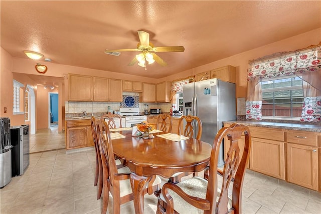 dining space with light tile patterned flooring, visible vents, a textured ceiling, and a ceiling fan