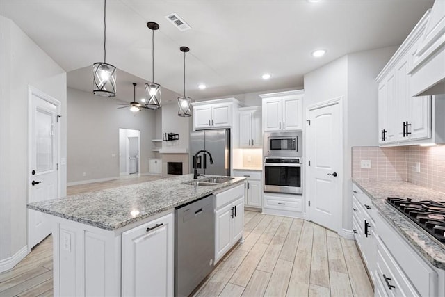 kitchen featuring visible vents, decorative backsplash, light wood-style floors, white cabinets, and stainless steel appliances