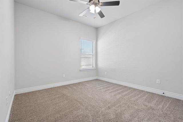 carpeted empty room featuring a ceiling fan and baseboards