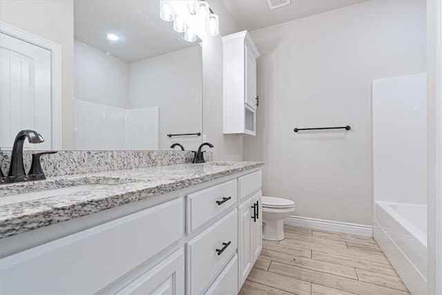 bathroom with walk in shower, toilet, wood finish floors, and double vanity