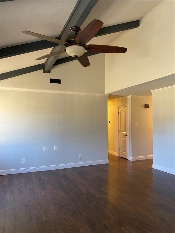 empty room with dark wood finished floors, vaulted ceiling with beams, a ceiling fan, and baseboards