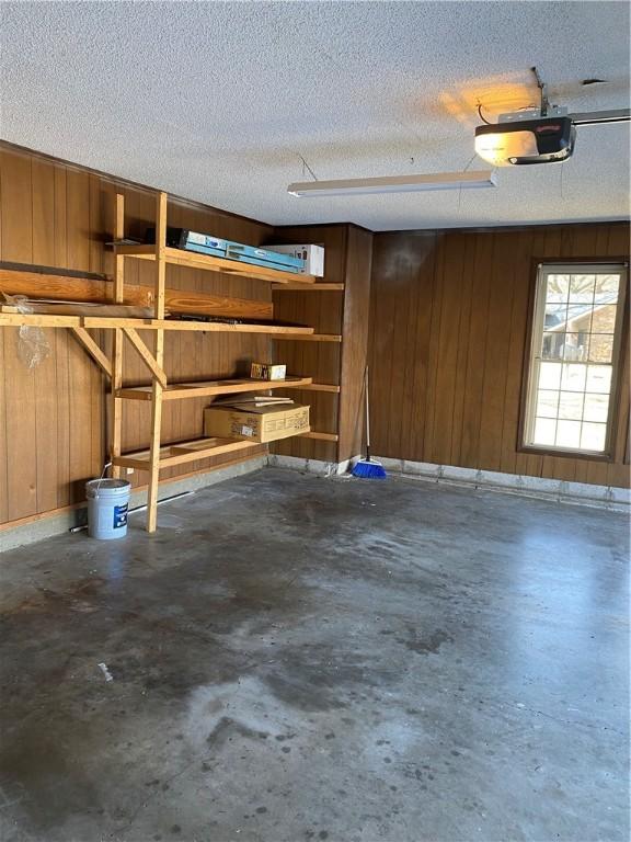 garage with wooden walls and a garage door opener