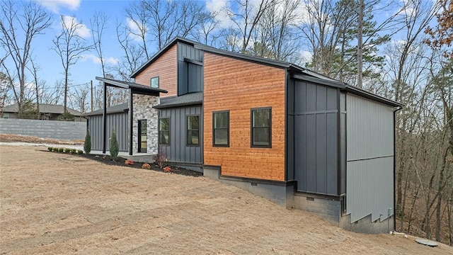 view of property exterior with crawl space and board and batten siding