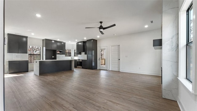 unfurnished living room with recessed lighting, wood finished floors, and a ceiling fan