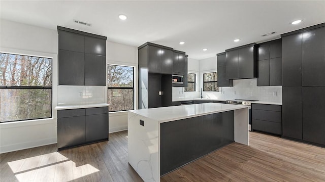 kitchen with dark cabinetry, visible vents, a sink, stainless steel appliances, and modern cabinets