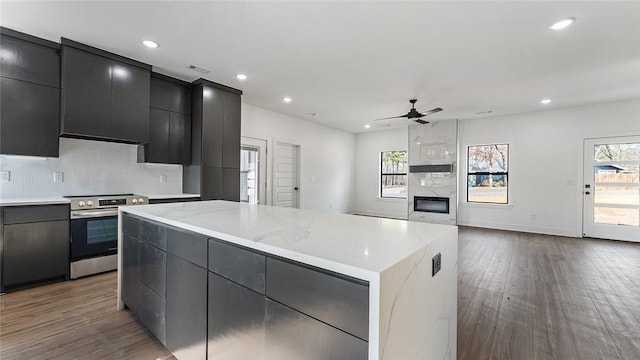 kitchen featuring dark cabinetry, electric stove, modern cabinets, and a center island