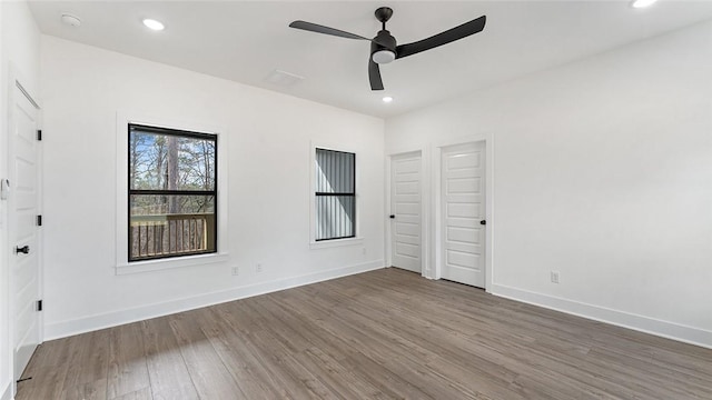 spare room with recessed lighting, wood finished floors, and baseboards