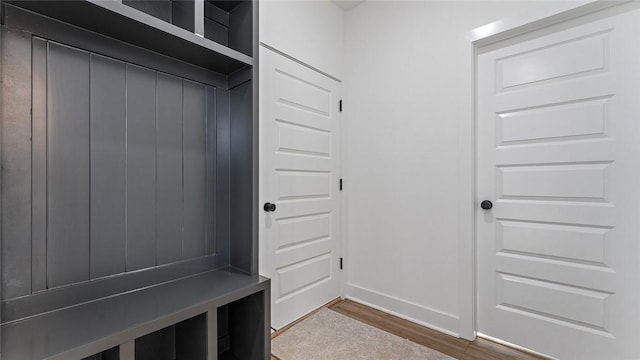 mudroom with dark wood-style floors and baseboards