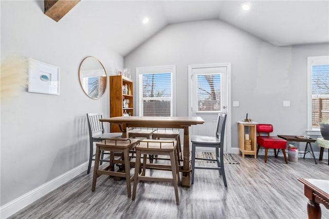 dining area with vaulted ceiling, baseboards, and wood finished floors