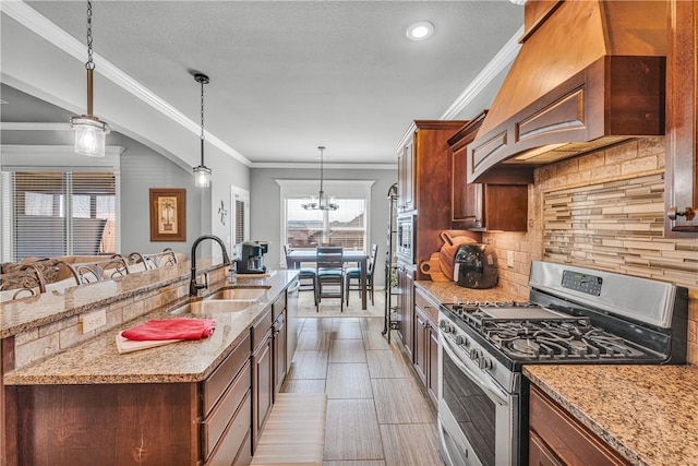 kitchen with light stone counters, custom exhaust hood, a sink, stainless steel appliances, and tasteful backsplash