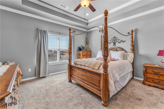 carpeted bedroom with visible vents, crown molding, a raised ceiling, and baseboards