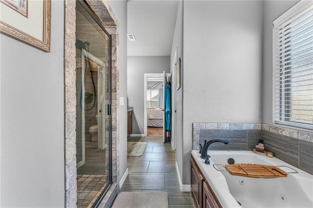 ensuite bathroom featuring a jetted tub, a stall shower, and ensuite bathroom