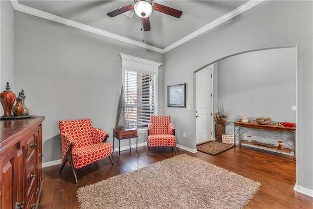 living area with arched walkways, crown molding, baseboards, and hardwood / wood-style floors