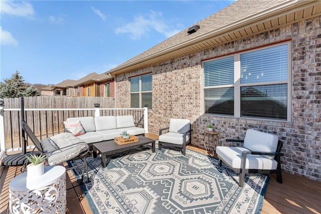 view of patio featuring outdoor lounge area, fence, and a wooden deck