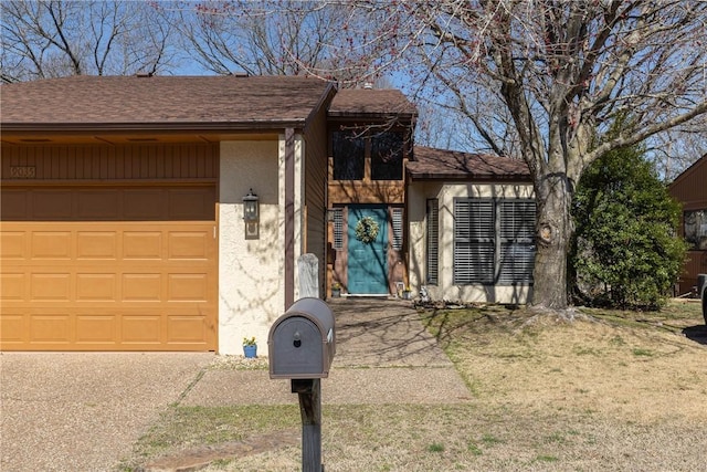 view of front of property with an attached garage, roof with shingles, and stucco siding