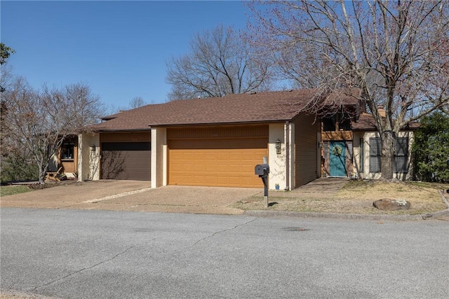 view of front of property with a garage, roof with shingles, and aphalt driveway