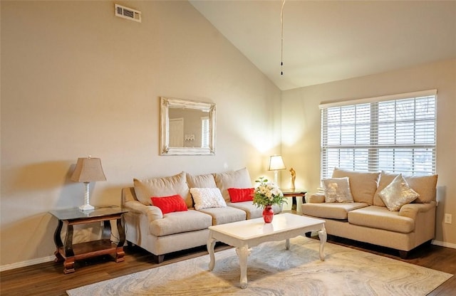 living room featuring visible vents, baseboards, high vaulted ceiling, and wood finished floors