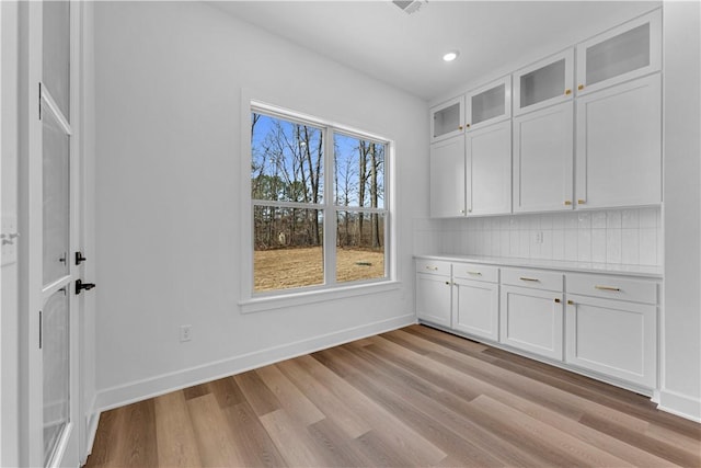 unfurnished dining area featuring recessed lighting, light wood-style flooring, and baseboards